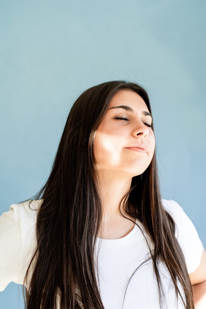 Portrait of brunette woman with reflection from light prism on her face