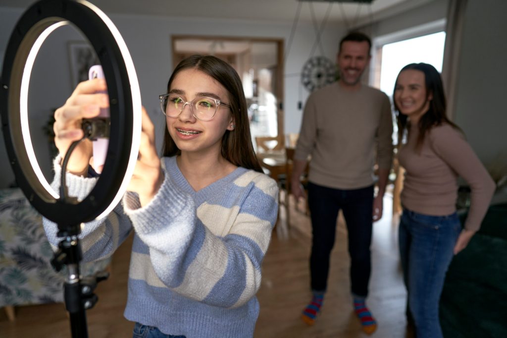 Teenager girl with parents recording dancing for social media